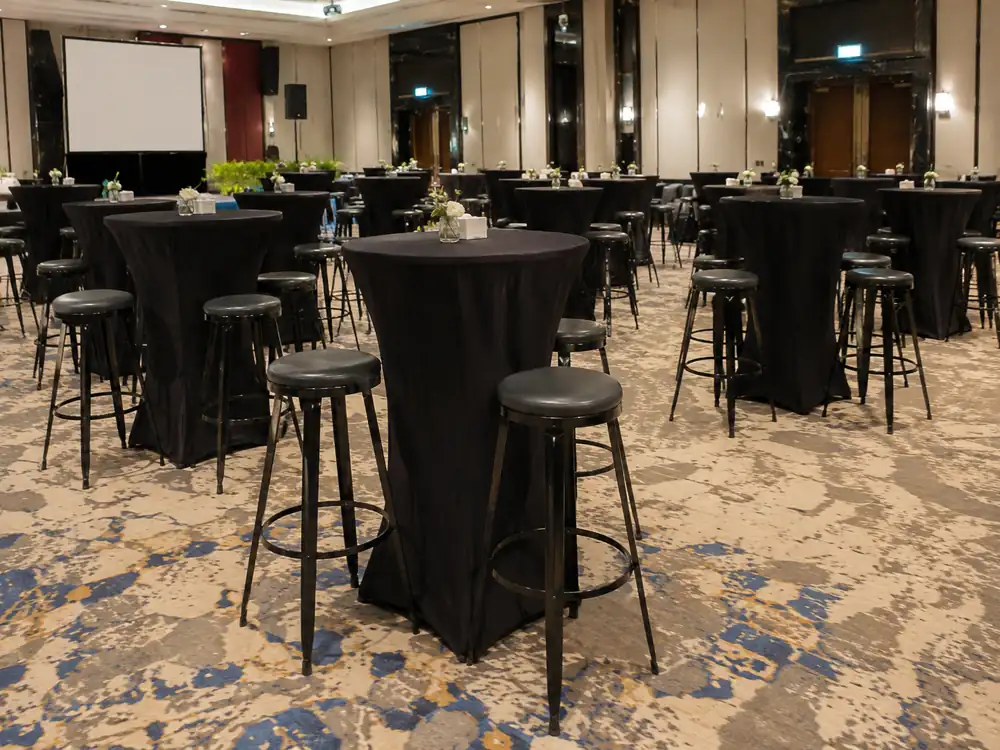 Black round seat bar stools and cocktail tables in a ballroom reception area