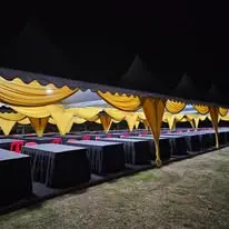 Night canopy setup with black and gold banquet tables
