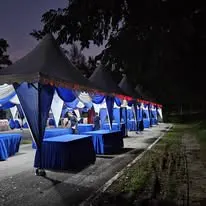 Night canopy setup with blue skirt tables