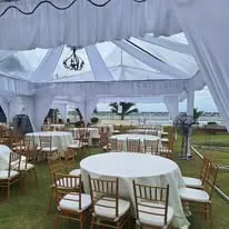 Round table and Chiavari chair setup under white canopy